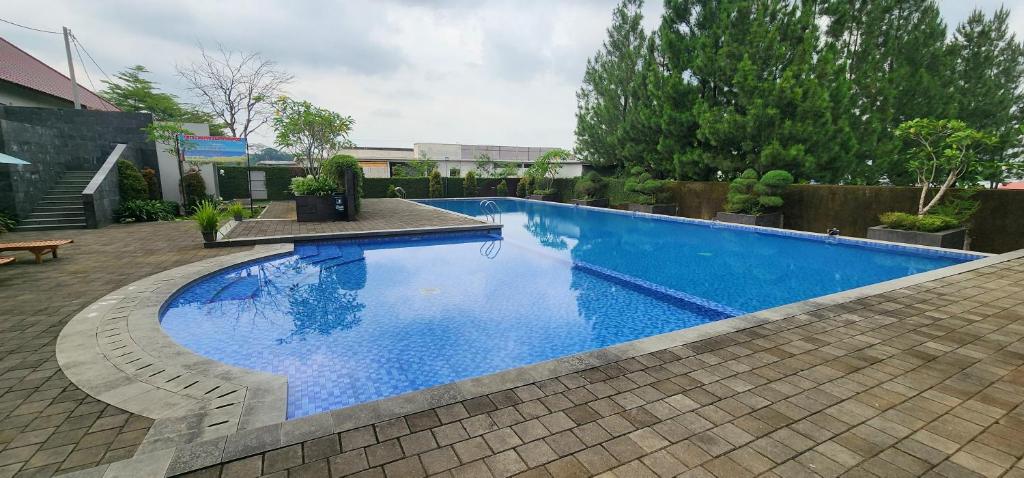 a large blue swimming pool in a yard at PEPABRI Hotel & Resort in Tjilimus