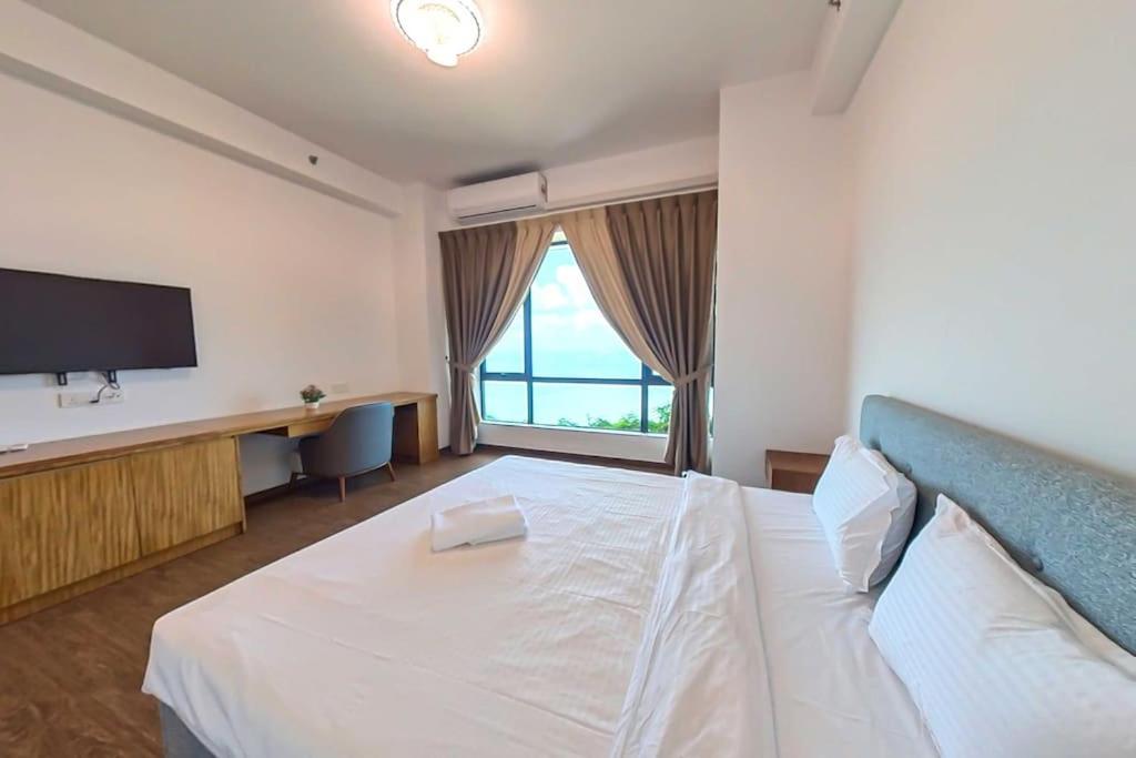 a bedroom with a large white bed and a television at Carnelian Tower - Forest City FC4226 in Gelang Patah