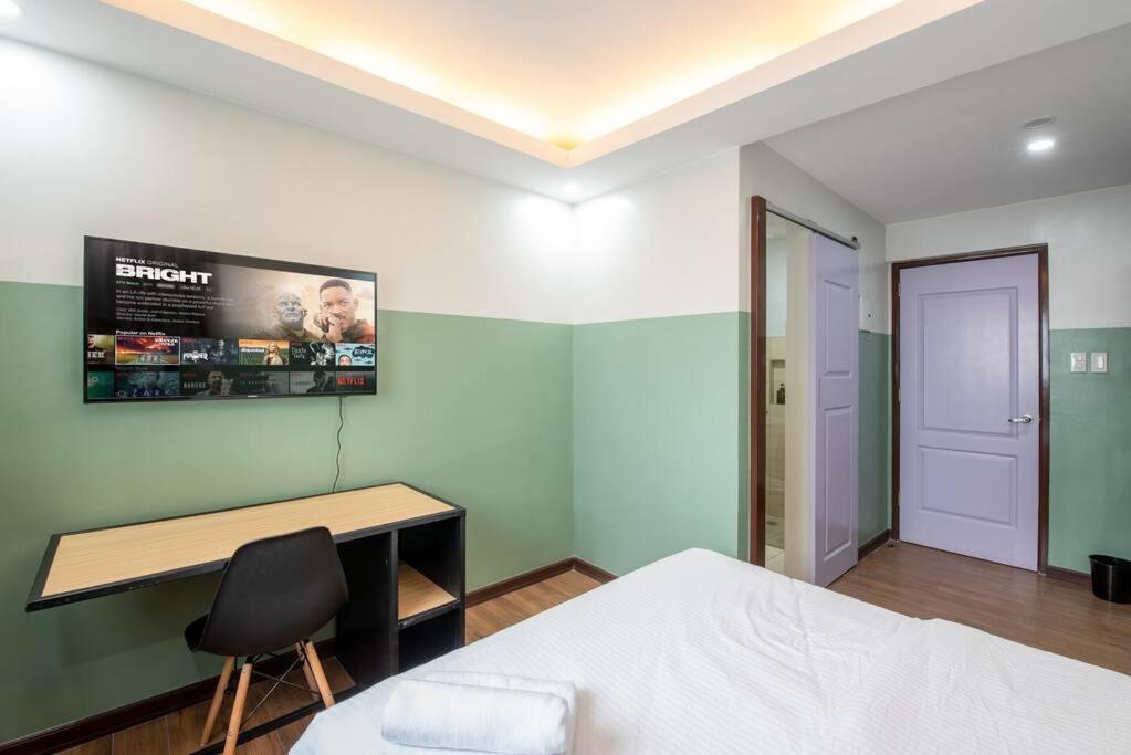 a bedroom with a bed and a desk and a monitor at St. Marvin Studio Makati M307 in Manila