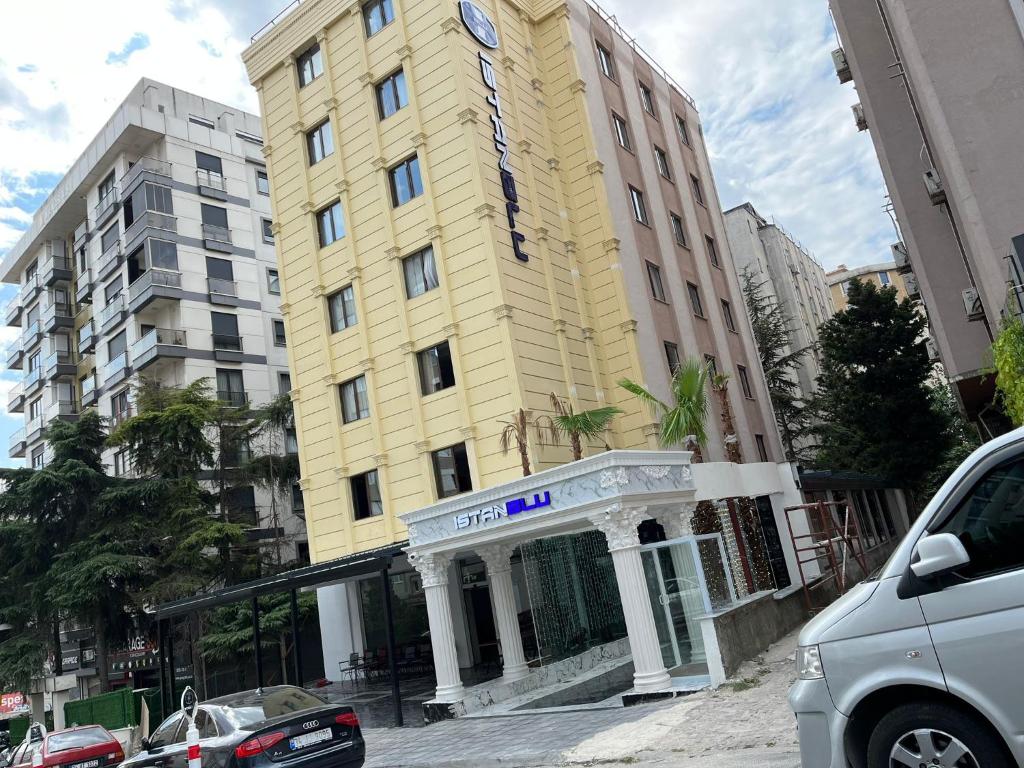 un grand bâtiment jaune avec une pancarte sur celui-ci dans l'établissement Istanblu Hotel Ataşehir, à Istanbul