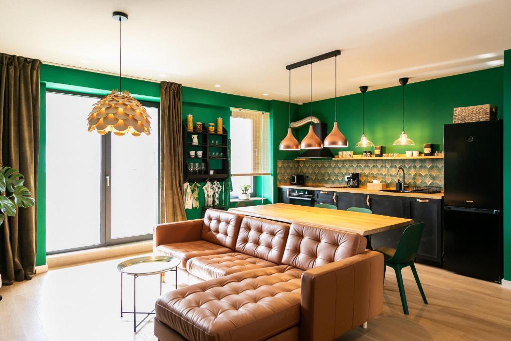 een woonkamer met een bank en een tafel bij Leaf Apartment - Aviatiei Home in Boekarest