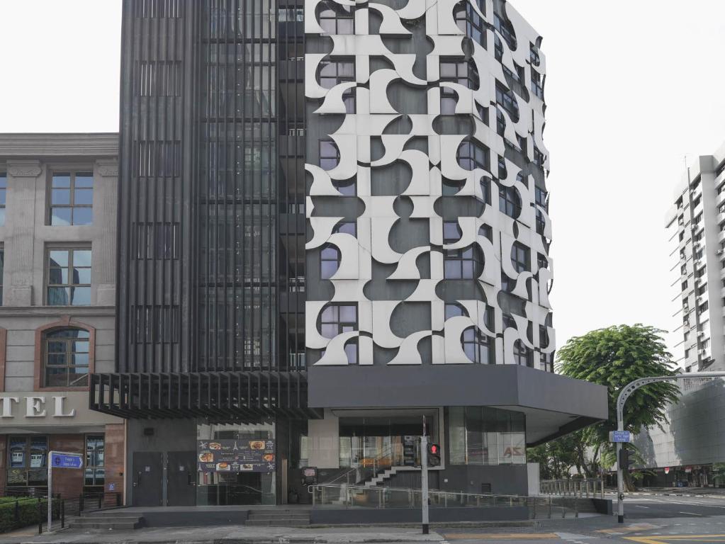 ein hohes Gebäude mit einer schwarz-weißen Fassade in der Unterkunft Amrise Hotel Kitchener in Singapur