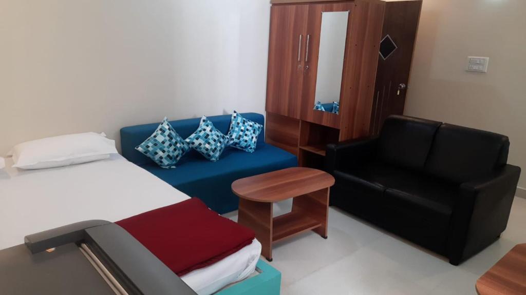 1 dormitorio con 1 cama, 1 sofá y 1 silla en Jenukal Nilaya en Mysore