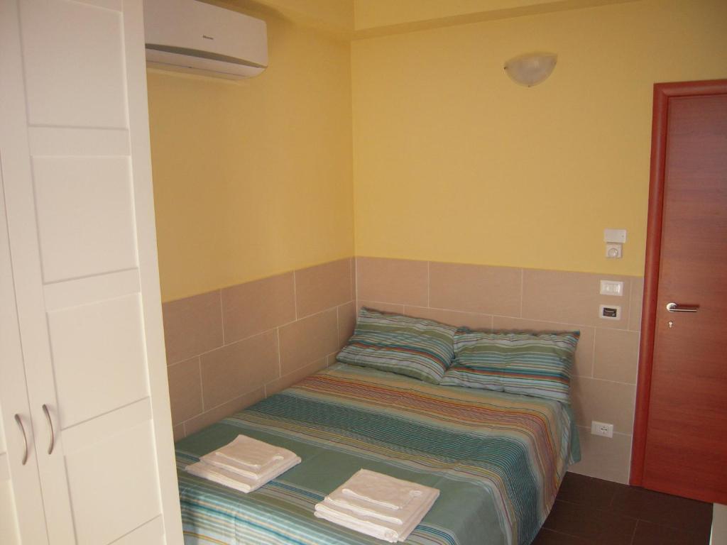 ボローニャにあるStudio Barcaの黄色い壁の客室の小さなベッド1台分です。