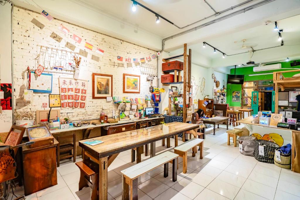 a restaurant with wooden tables and a brick wall at Fuqi Hostel - Yuanqi in Tainan
