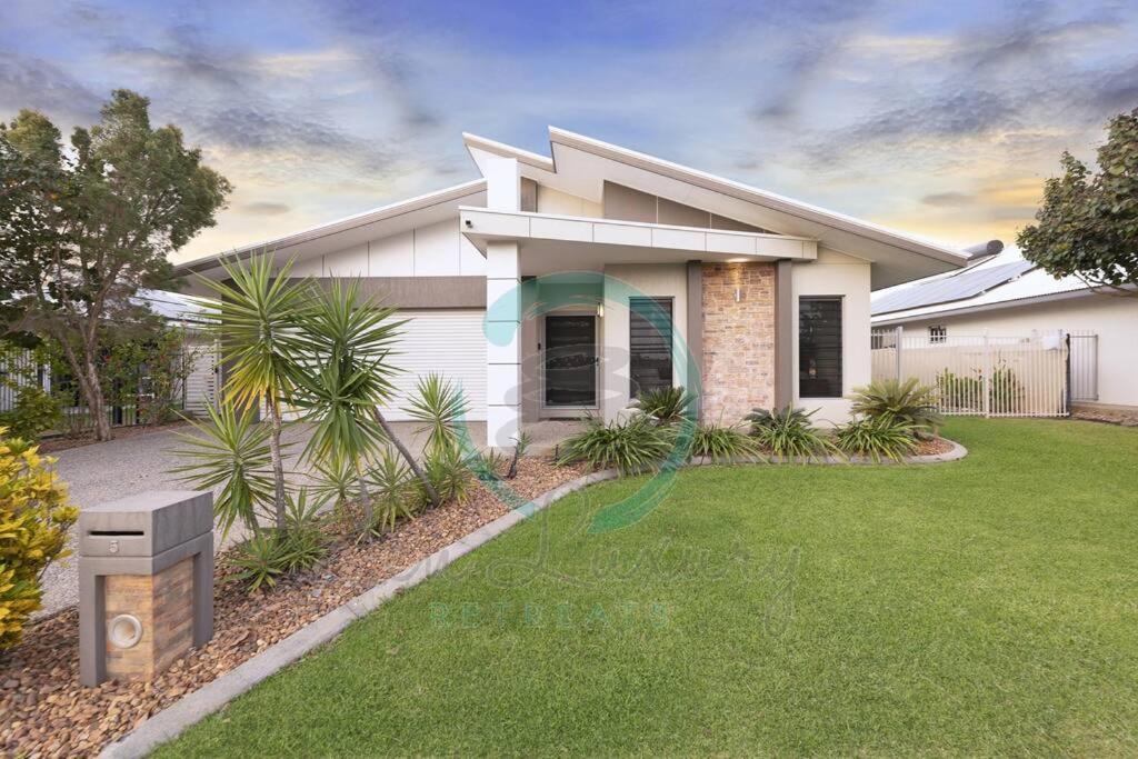 a white house with a lawn in front of it at Zenhouse: 4BR Stylish Work/Family Home in Muirhead in Leanyer