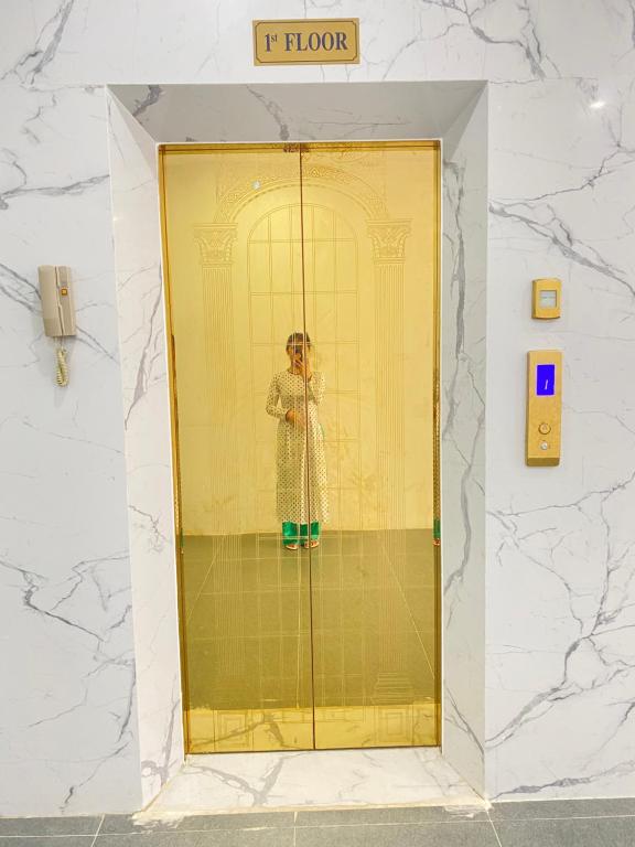a woman standing in a elevator in a building at GOODTECH LUXURY Hotel & Apartment in Danang