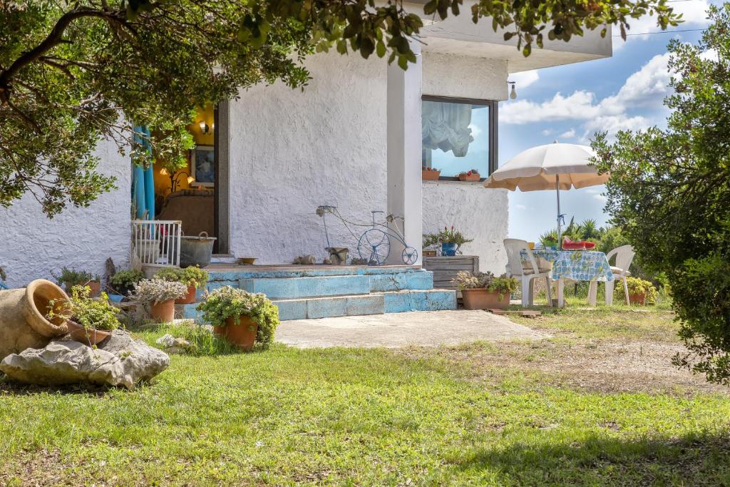 a house with stairs and an umbrella in the yard at Villa Maria Antonietta in Sassari