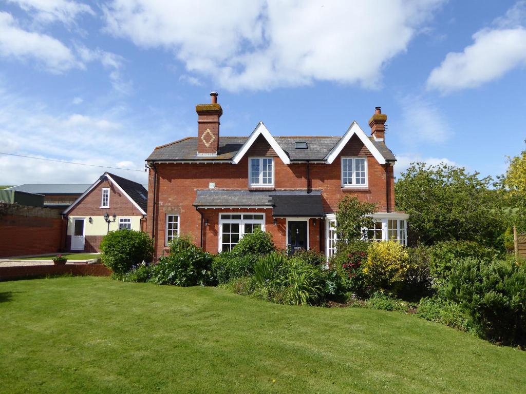 a large red brick house with a green yard at Pump Cottage in Weymouth