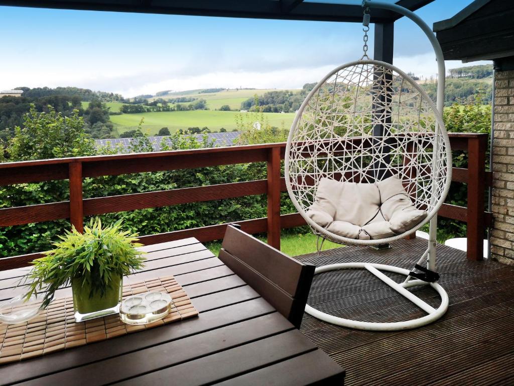 einen Schaukelstuhl auf einer Veranda mit einem Tisch in der Unterkunft Ferienhaus IRENE in Meschede