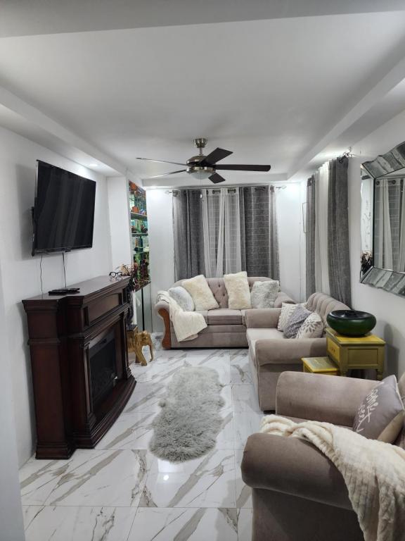 a living room with couches and a flat screen tv at 11onEssex1 in the heart of Kingston Ja DN Vacations in Kingston