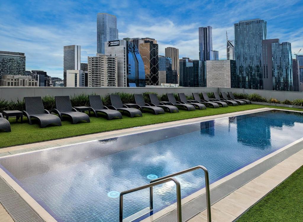 a swimming pool with chairs on the roof of a building at Wyndham Hotel Melbourne in Melbourne