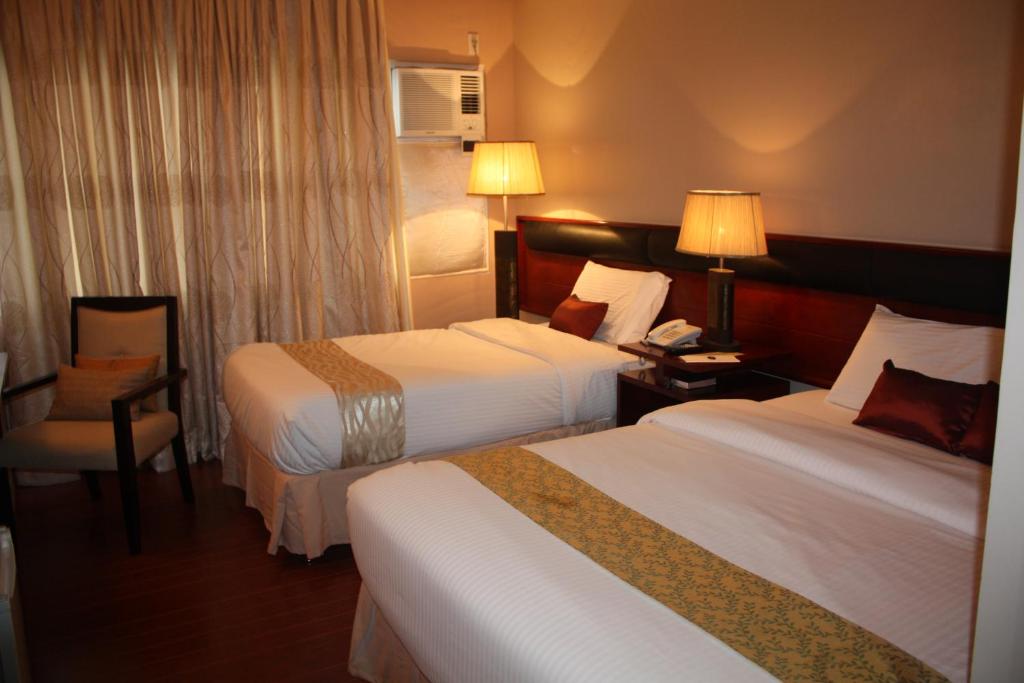 Postel nebo postele na pokoji v ubytování Allure Hotel & Suites