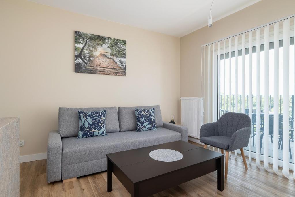 a living room with a couch and a table at Tauron Arena Crakow Apartment with Parking by Renters in Krakow