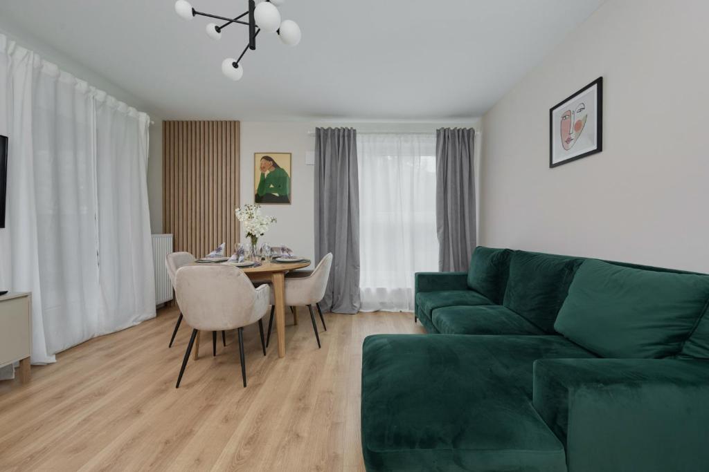 弗次瓦夫的住宿－Beautiful 3-Bedroom Apartment Gwiaździsta 18 by Renters，客厅配有绿色沙发和桌子
