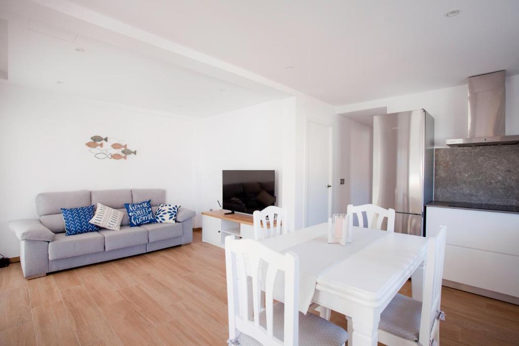een woonkamer met een witte tafel en een bank bij Acogedor apartamento junto al mar in Oliva