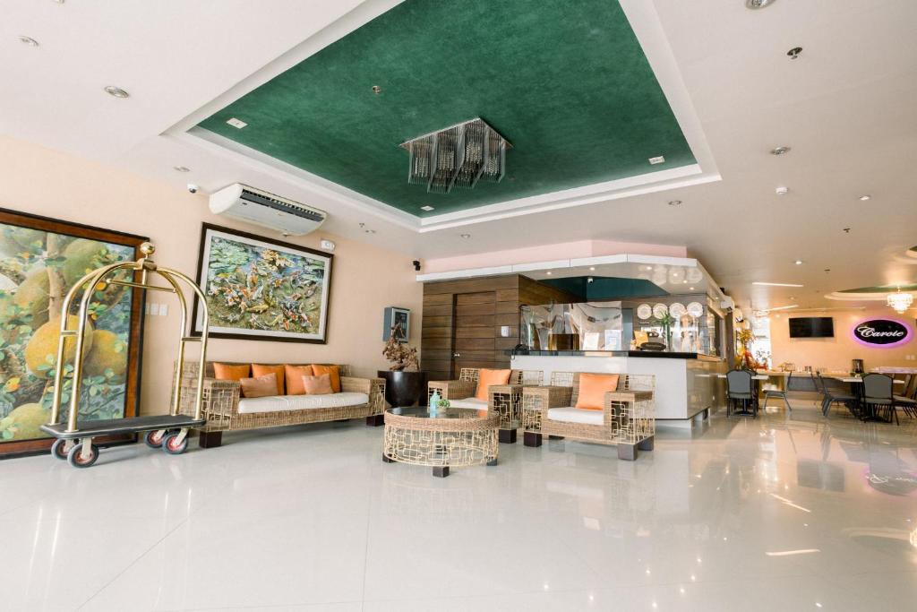 ein Wohnzimmer mit Möbeln und einer grünen Decke in der Unterkunft Allure Hotel & Suites in Cebu City