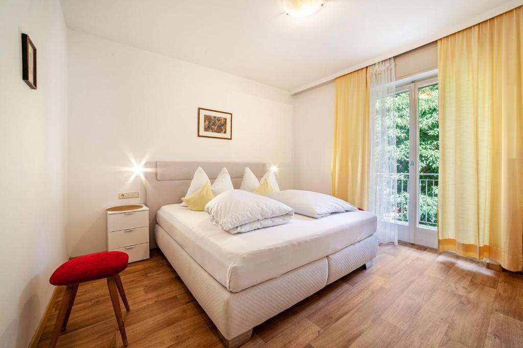 Un dormitorio con una cama blanca y una ventana. en Villa Sabine - Sabine, en Merano