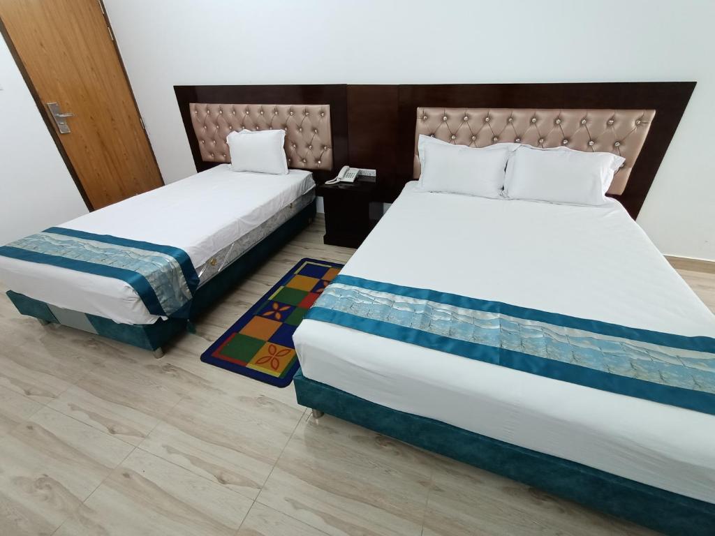 two beds sitting next to each other in a room at Hotel D-Palace in Dhaka