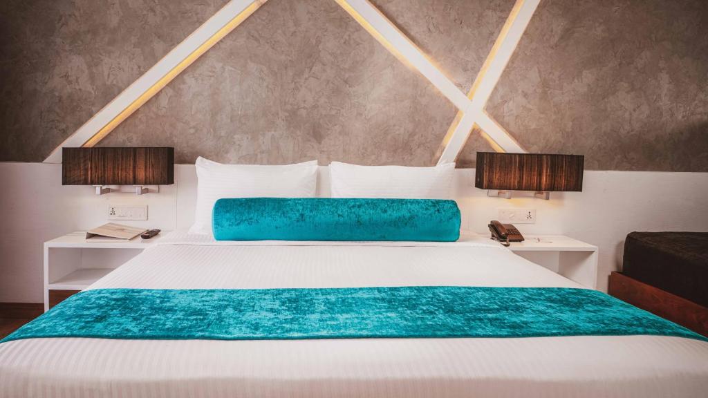 ネゴンボにあるキャメロット バイ ザ シー ホテルのベッドルーム(白いベッド、青い毛布付)