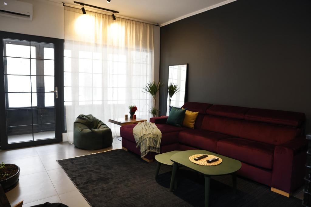 sala de estar con sofá rojo y mesa en Oldtown Apartment in Prishtina en Pristina