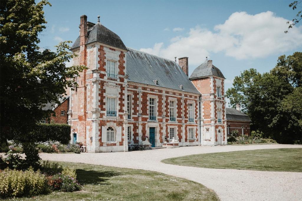 a large brick building with a roof at Le château de Bonnemare - Bed and breakfast in Radepont
