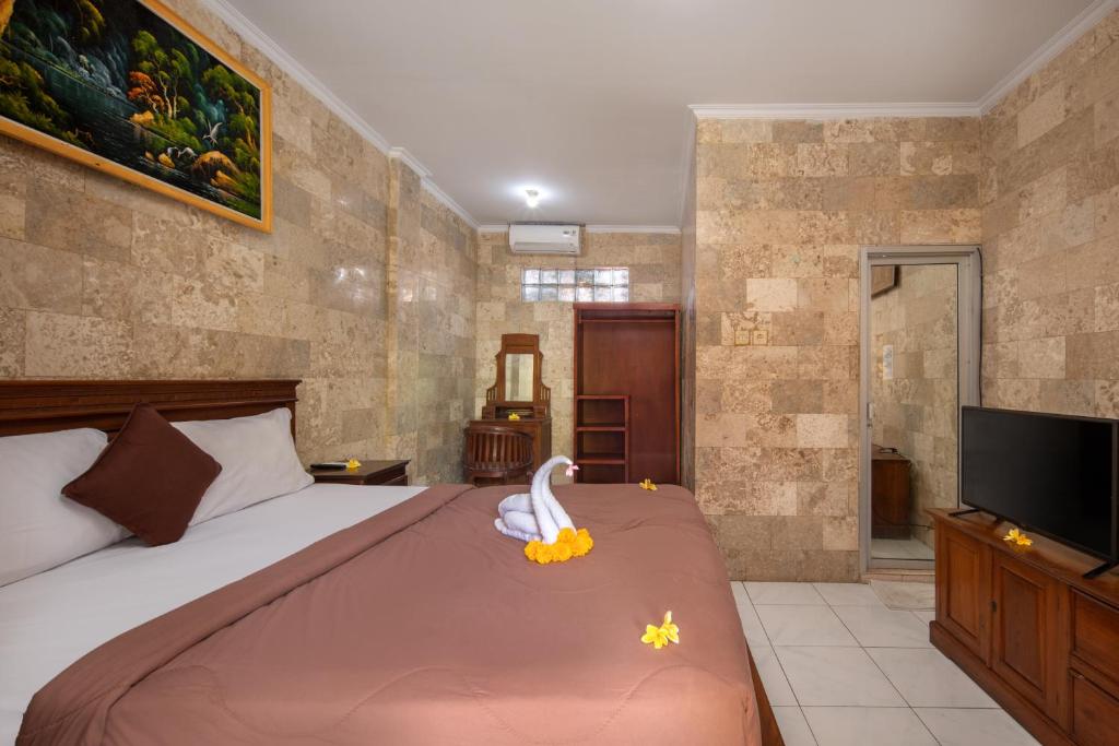 Postel nebo postele na pokoji v ubytování Hotel Lumbung Sari Legian