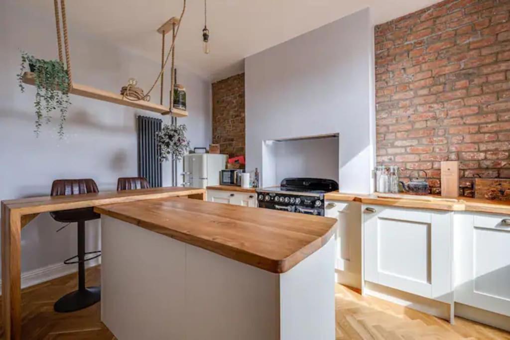 een keuken met witte kasten en een bakstenen muur bij Duplex Apartment - City Centre in Chester