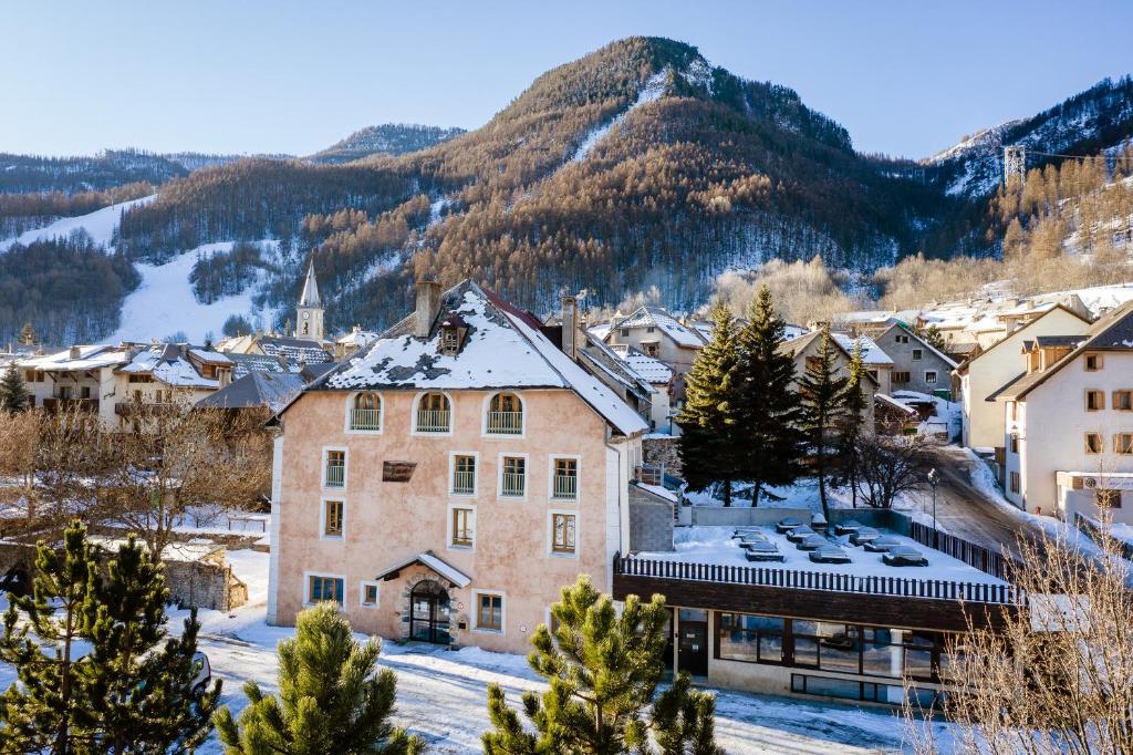 una ciudad en las montañas con nieve en el suelo en Auberge de Jeunesse HI Serre-Chevalier en La Salle Les Alpes