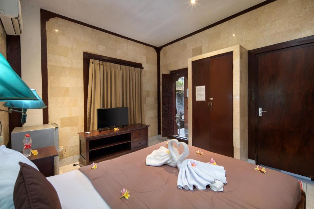 Postel nebo postele na pokoji v ubytování Hotel Lumbung Sari Legian