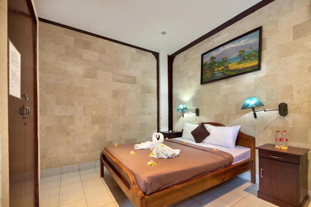 Postel nebo postele na pokoji v ubytování Hotel Lumbung Sari Legian
