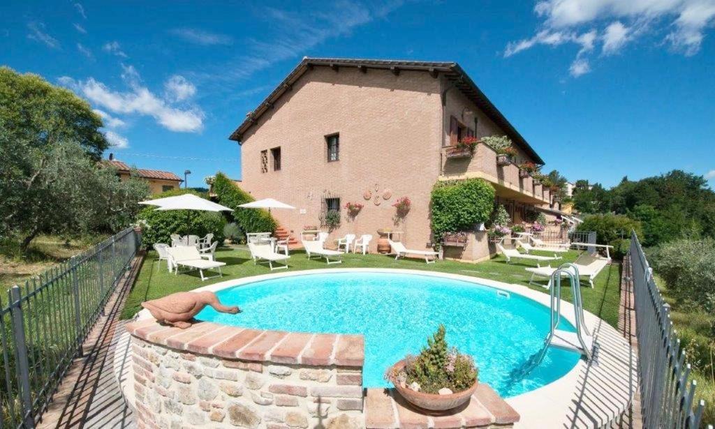 a house with a swimming pool in front of a house at ISA-Holiday-Home with swimming-pool in San Gimignano, apartments with air conditioning and private outdoor area in San Gimignano
