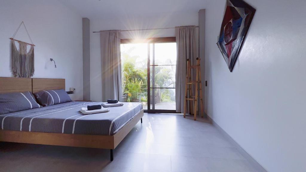 a bedroom with a bed and a large window at Mantra Sea View Villa in Chaloklum