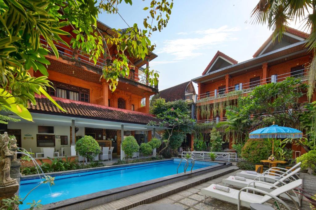 an image of the courtyard of a hotel with a swimming pool at Hotel Lumbung Sari Legian in Legian