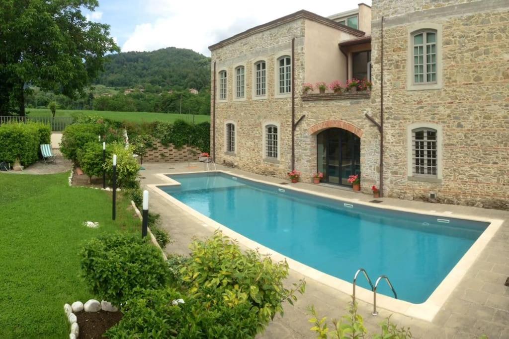 a large swimming pool in front of a house at Casa Fevira Borgo in Borgo San Lorenzo