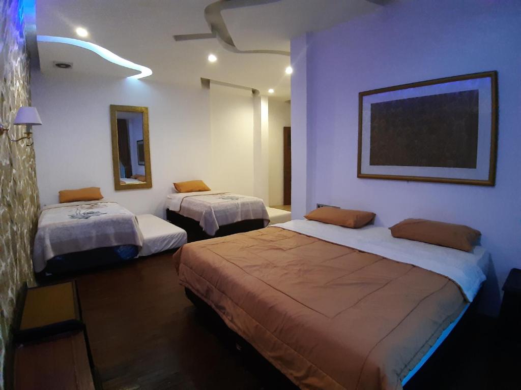 a room with two beds and a painting on the wall at De Summit Villa & View in Puncak