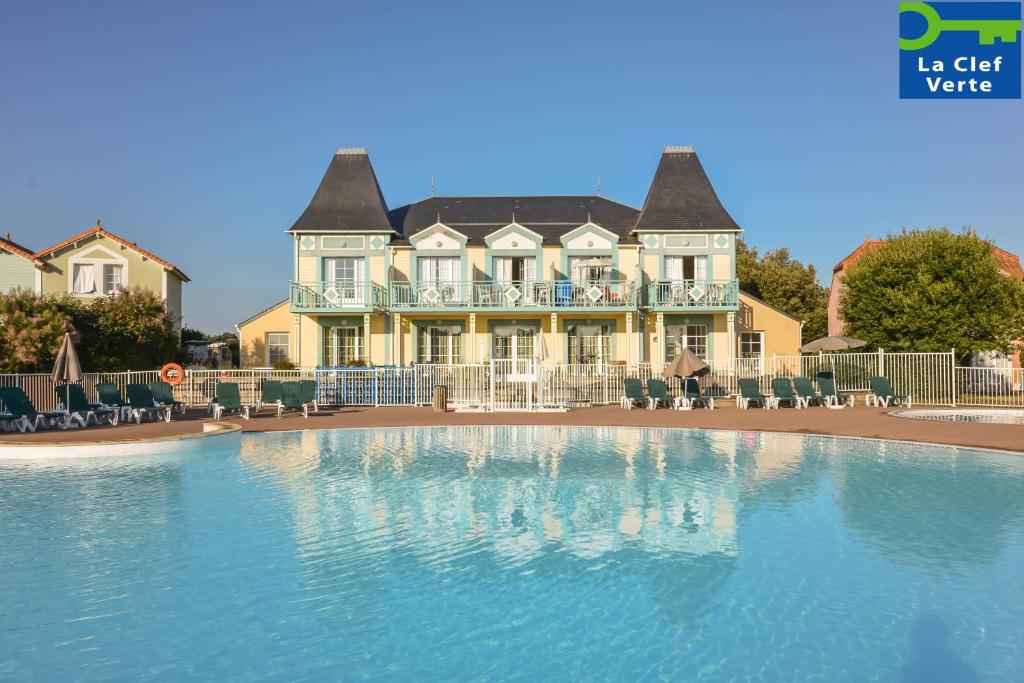 una casa grande con piscina frente a ella en Résidence Pierre & Vacances Le Domaine de Bourgenay, en Talmont
