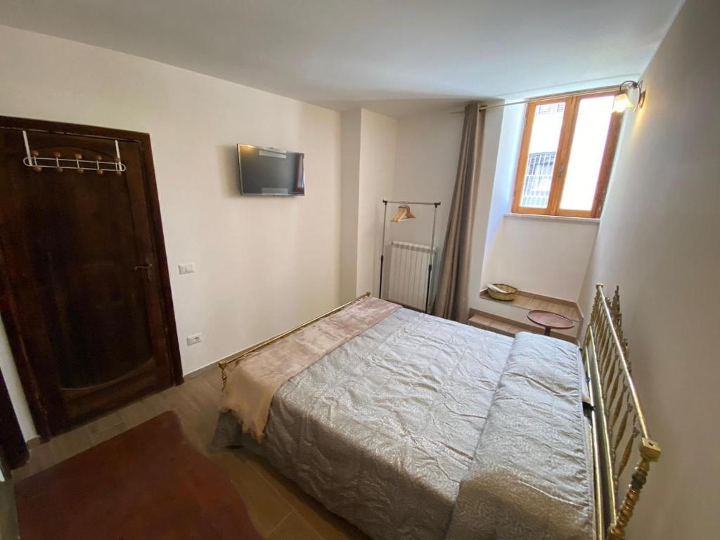 TuraniaにあるB&B La Cortesiaのベッドルーム1室(ベッド1台、壁掛けテレビ付)