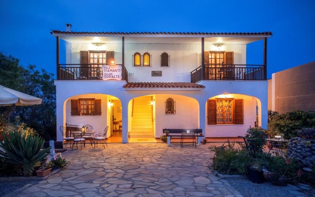 Biały dom z żółtymi drzwiami i patio w obiekcie Villa Diamanti w mieście Monemwasia