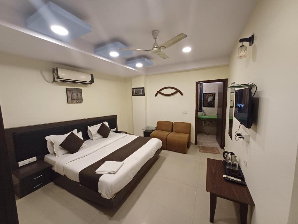 a bedroom with a bed and a television in it at Hotel V inn Sindhi Camp in Jaipur