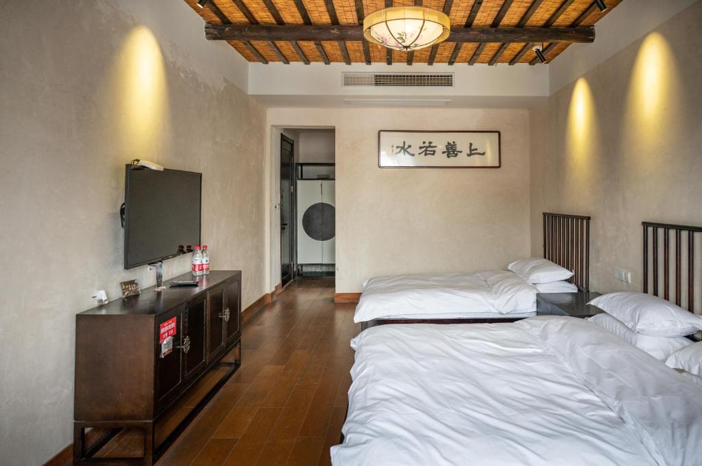 Postel nebo postele na pokoji v ubytování Tingjian Musu Private Soup Design Homestay - South Gate of Wuzhen Xizha Scenic Area