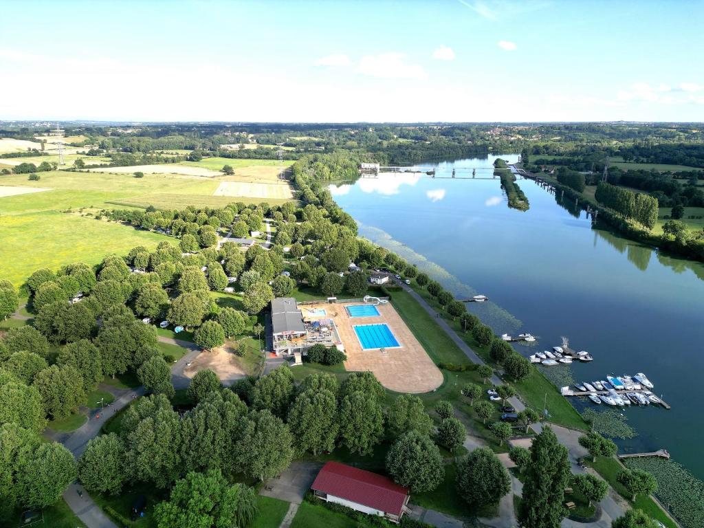 - une vue aérienne sur un lac avec une piscine dans l'établissement Camping De Thoissey ***, à Thoissey