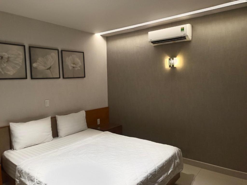 a bedroom with a bed and a air conditioner on the wall at Hotel Bông Sen in Ho Chi Minh City