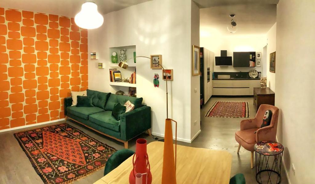 Casa del vicolo Fortunato في تشيفيتافيكيا: غرفة معيشة مع أريكة خضراء وكرسي