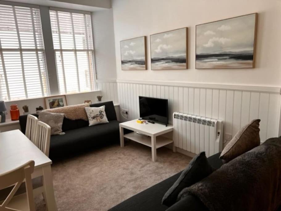 a living room with a couch and a tv at 73 George Street. Appartment 1 in Oban