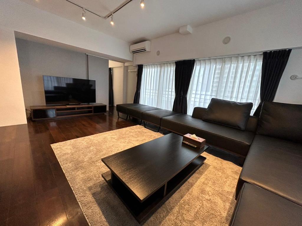 NIYS apartments 74 type في طوكيو: غرفة معيشة مع أريكة وطاولة قهوة