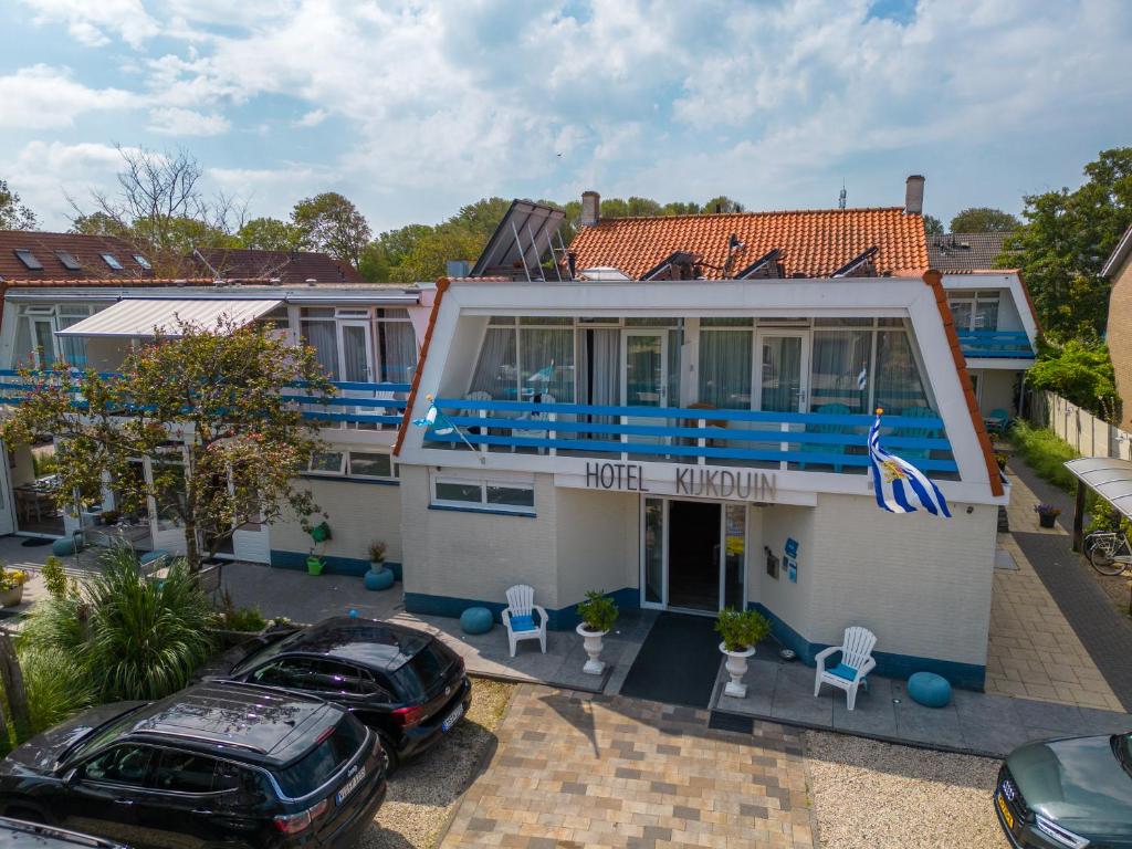 a house with a car parked in front of it at Hotel Kijkduin in Domburg