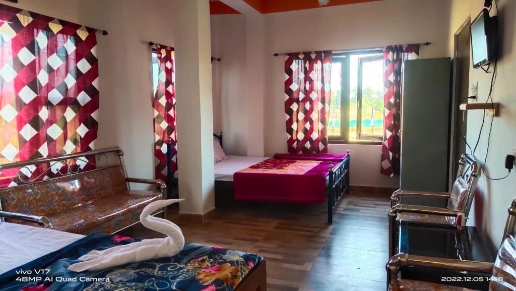 ein Zimmer mit 2 Betten und ein Zimmer mit einem Fenster in der Unterkunft KANAK RESIDENCY in Chālsa Mahābāri