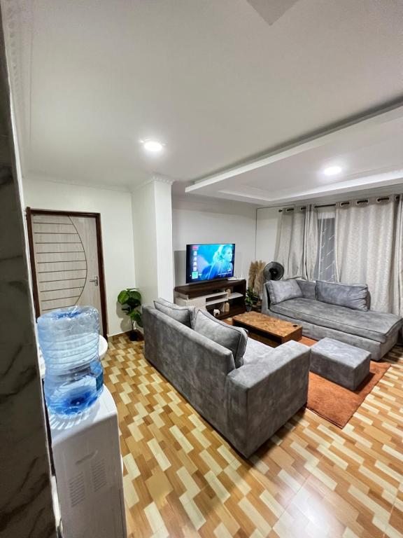 ein Wohnzimmer mit 2 Sofas und einem Flachbild-TV in der Unterkunft Ruyer one bedroom in Kisumu