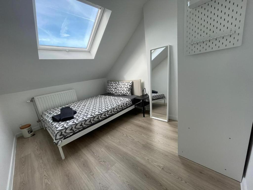 Schaerbeek Room 2 في بروكسل: غرفة بيضاء مع سرير ومرآة